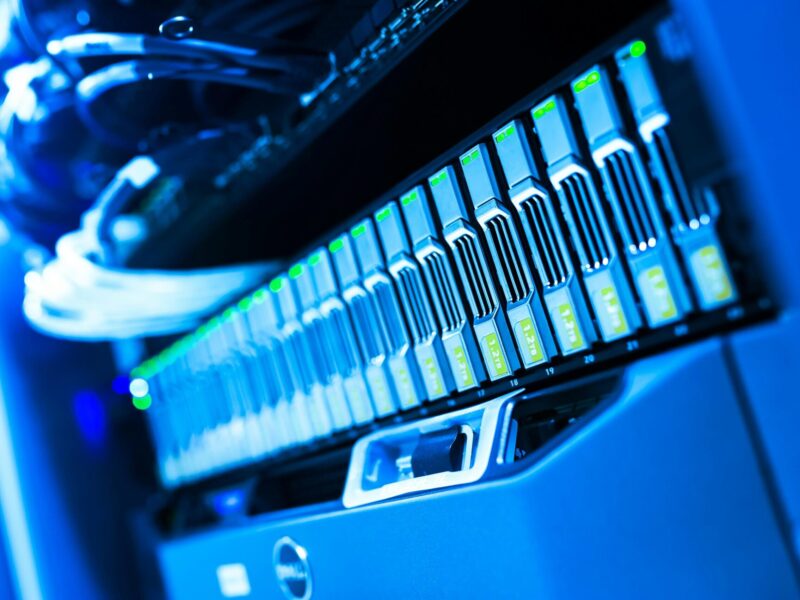 A detailed view of a blue lit computer server rack in a data center showcasing technology and hardware.