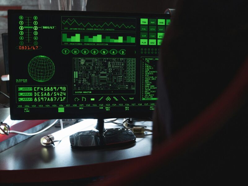 View of a computer monitor displaying green digital security code in an indoor setting.