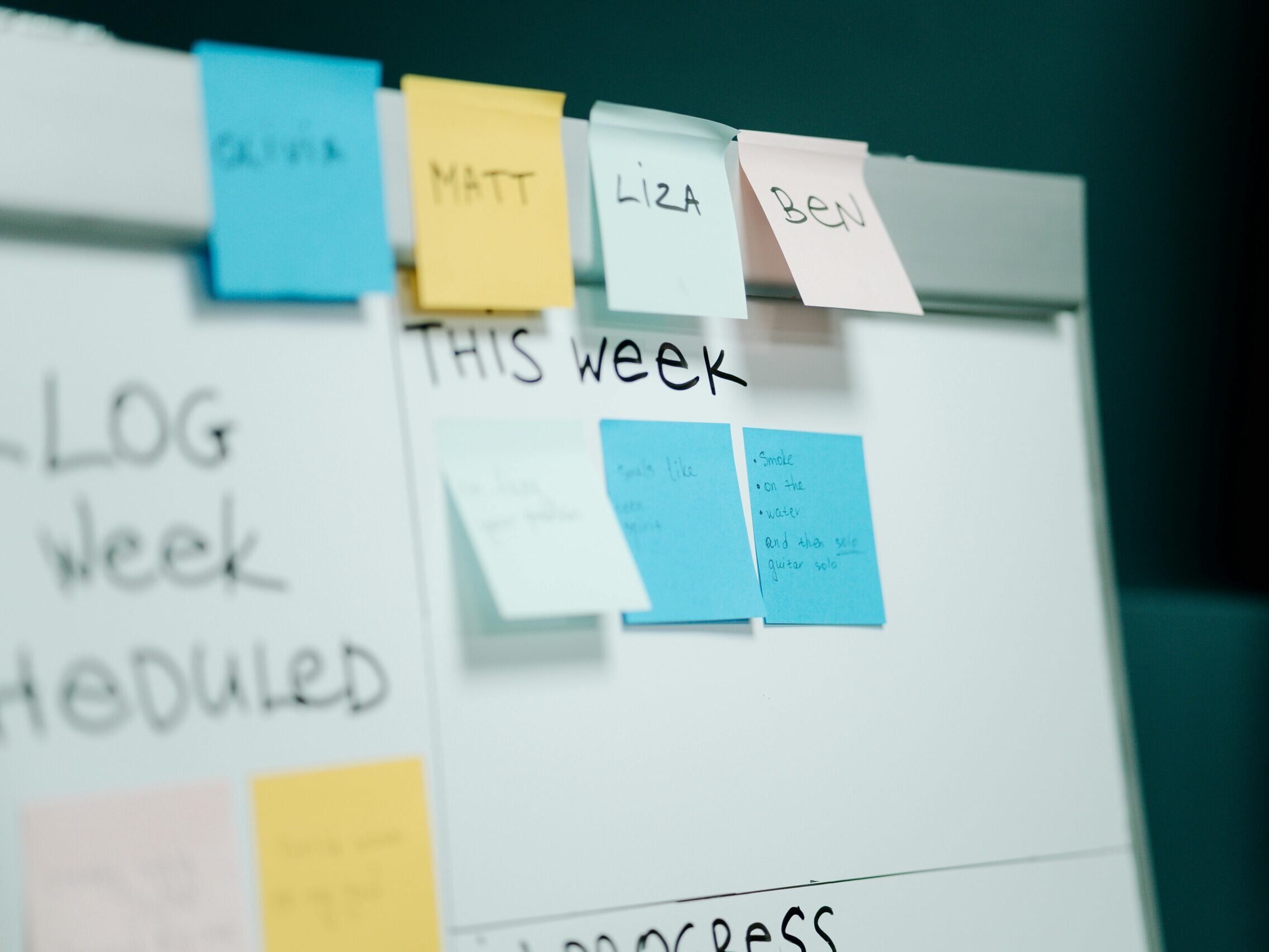 Close-up of a whiteboard with colorful sticky notes for task organization and planning.