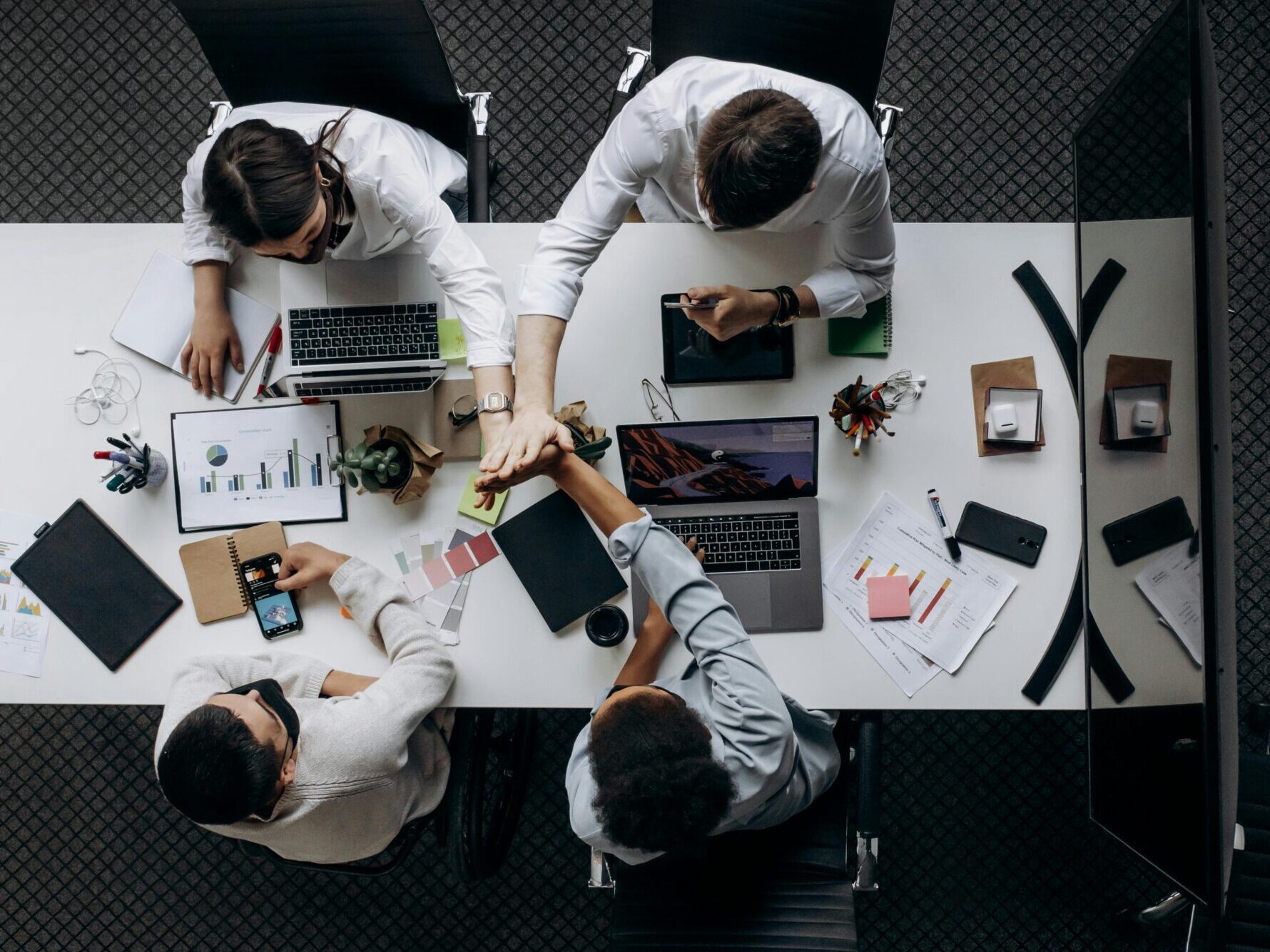 High angle view of colleagues collaborating around a conference table in a modern office setting.