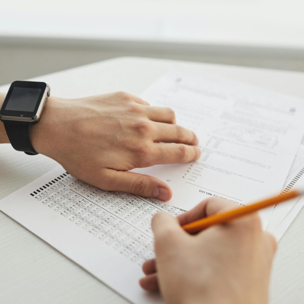 Student completing a multiple-choice exam with a pencil, close-up view.