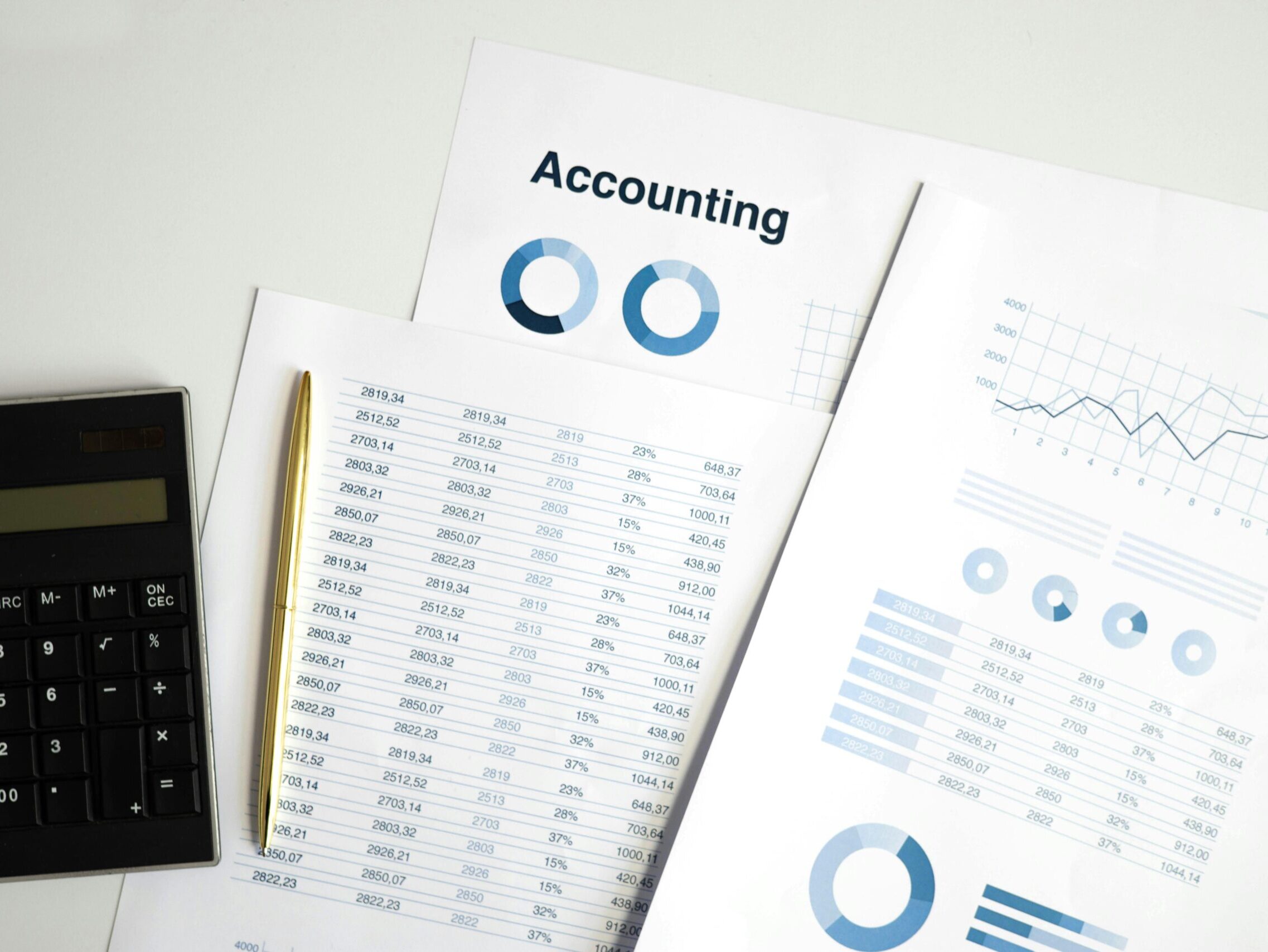 Calculator and accounting documents with charts on a workspace.