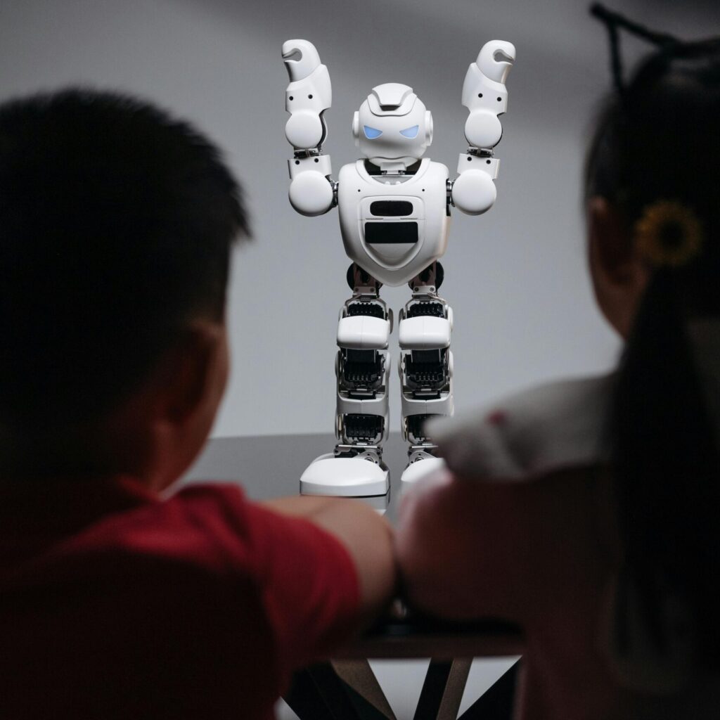 Two children observe a humanoid robot on a table, exploring technology and innovation.