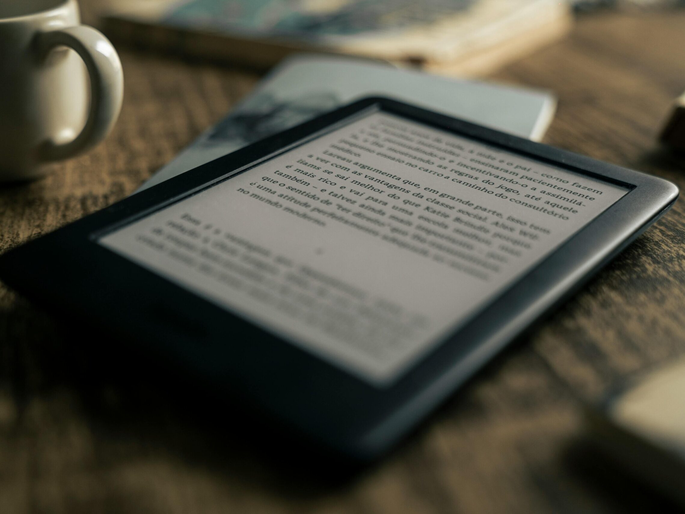 A tablet displaying an ebook on a wooden table next to a coffee cup, ideal for tech and lifestyle themes.