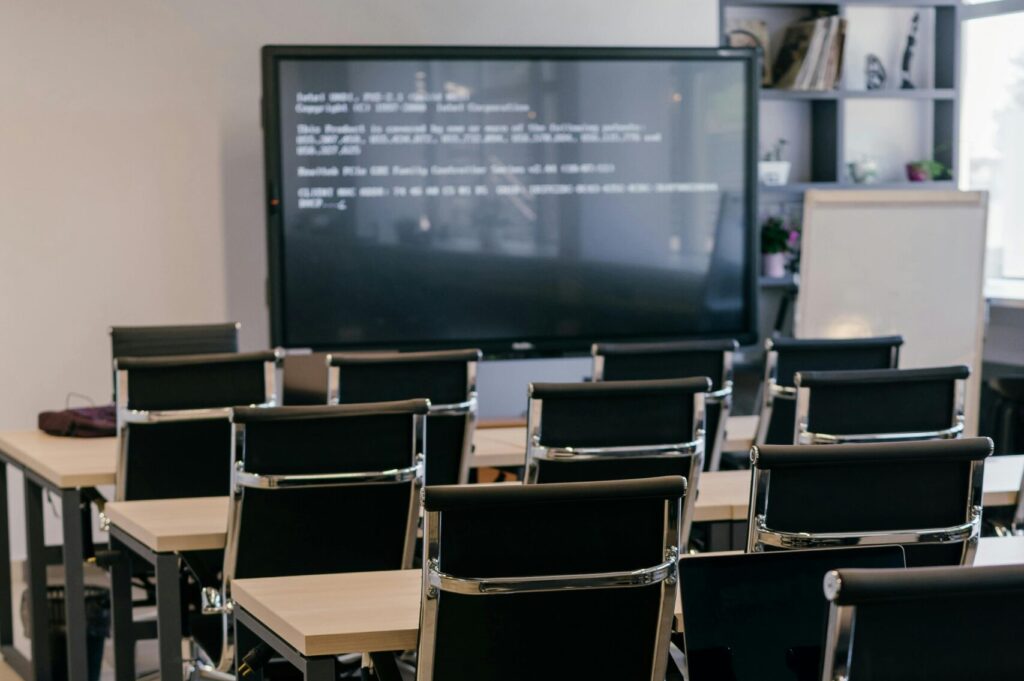 diagnostic-lab-case-gallery-4 Contemporary office space with sleek black leather chairs and a large screen for presentations.
